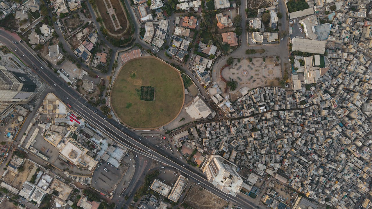 A detailed aerial shot of Karachi showing dense settlements and a distinct circular park, highlighting urban development.